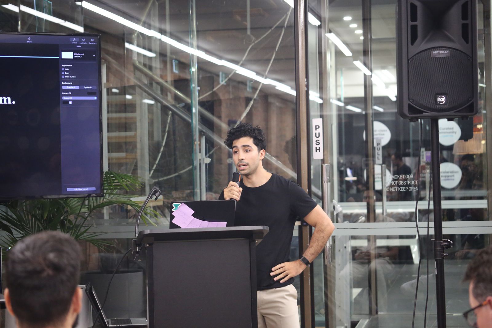 Faisal Taibi talking with the audience beside the lectern.